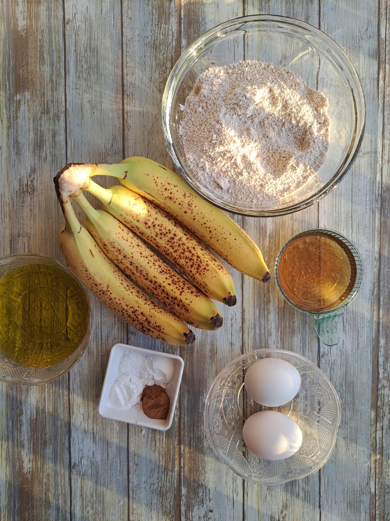A bunch of banana, a bowl of flour, 2 eggs, a bowl of honey, 1/2 cup of olive oil